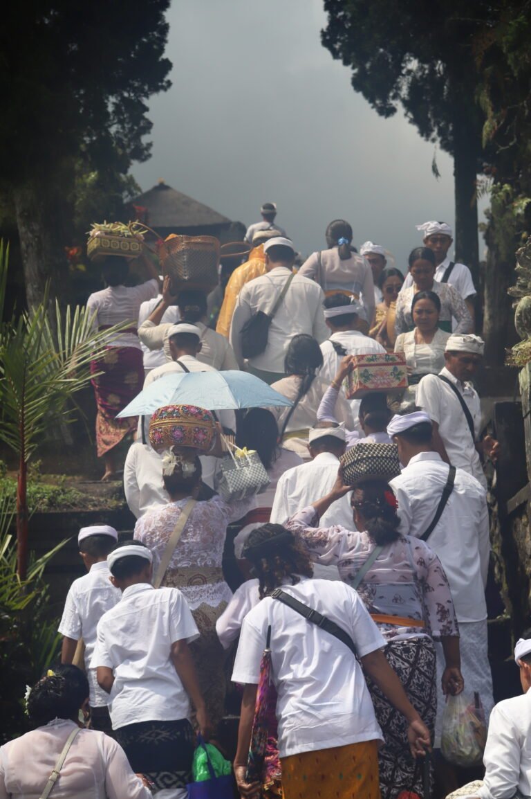 Participants vêtus avec des habits traditionnels blancs pour la célébration de Kuningan au temple Pura Besakih à Bali montant les marches